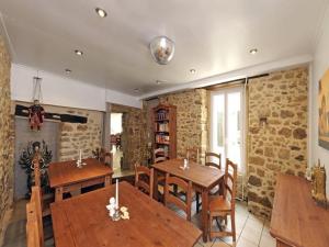 een eetkamer met houten tafels en stoelen bij Maison des Anges in Bouin