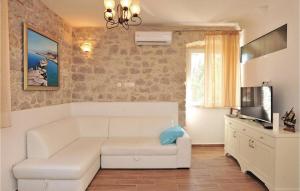 a living room with a white couch and a tv at Villa Luka Brac in Ložišće