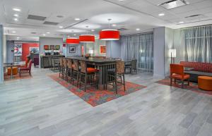 a lobby with a bar with chairs and a kitchen at Hampton Inn Vincennes in Vincennes