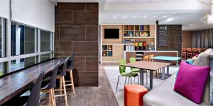 Home2 Suites by Hilton Ocean City Bayside في آوشين سيتي: مطعم مع طاولة وكراسي وغرفة طعام