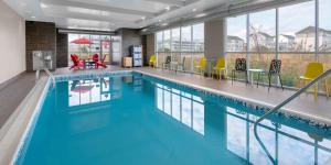 a large swimming pool with blue water in a building at Home2 Suites by Hilton Ocean City Bayside in Ocean City