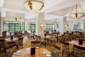 a restaurant with tables and chairs and windows at Hilton Ocala in Ocala