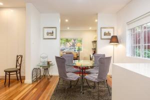 a dining room with a table and chairs at Exclusive Art Deco Escape in Tree-lined Kingsford in Sydney