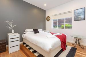 a bedroom with a large bed and a table at Exclusive Art Deco Escape in Tree-lined Kingsford in Sydney