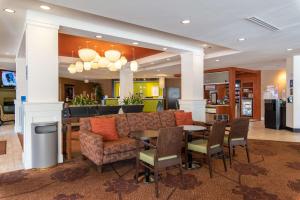 eine Lobby mit einem Restaurant mit einem Tisch und Stühlen in der Unterkunft Hilton Garden Inn Ogden in Ogden