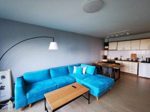 a living room with a blue couch and a kitchen at Chill and sea in Kavarna
