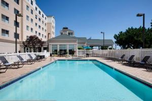 a swimming pool with chairs and a building at Hilton Garden Inn Oklahoma City Airport in Oklahoma City
