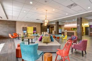 Home2 Suites by Hilton OKC Midwest City Tinker AFB في ميدويست سيتي: لوبى مع كراسي وطاولات ملونة وأريكة