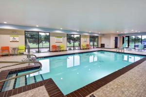 a large swimming pool with blue water in a building at Home2 Suites By Hilton El Reno in El Reno