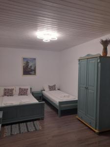 a room with two beds and a cabinet in it at Casa Davina in Sasca Montană