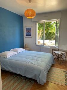 - une chambre avec un grand lit et un mur bleu dans l'établissement Maison Familiale idéale pour les Vacances/Weekends, à Dinard