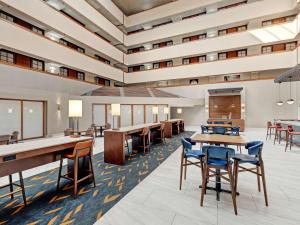 an office lobby with tables and chairs at Embassy Suites by Hilton Oklahoma City Will Rogers Airport in Oklahoma City