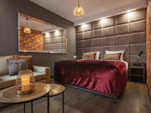 una camera con letto rosso e sedia di Art Suites Boutique Hotel - Krakow Center a Cracovia