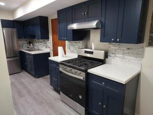 uma cozinha com armários azuis, um fogão e um lavatório em Casa Cerca De La Playa em Chicago