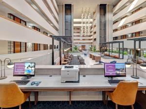 a large lobby with two computers on a table at Embassy Suites by Hilton Oklahoma City Will Rogers Airport in Oklahoma City