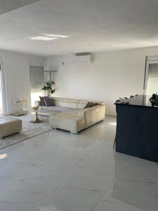 a white living room with a couch and a table at Apartment Ajdarpasic in Bar +1 photo