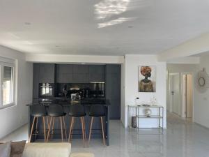 a kitchen with black cabinets and bar stools at Apartment Ajdarpasic in Bar