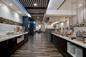 uma grande cozinha com um longo corredor com mesas em Embassy Suites By Hilton Oklahoma City Northwest em Oklahoma City
