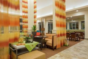 a lobby with a restaurant with tables and chairs at Hilton Garden Inn Olympia, WA in Olympia