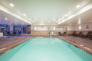 奧林匹亞的住宿－華盛頓州奧林匹亞希爾頓花園酒店，大楼内一个蓝色的大型游泳池