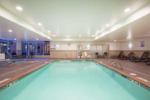a large swimming pool with blue water in a building at Hilton Garden Inn Olympia, WA in Olympia