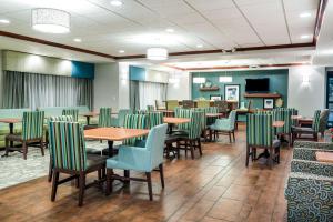 uma sala de jantar com mesas e cadeiras verdes em Hampton Inn Bellevue em Bellevue