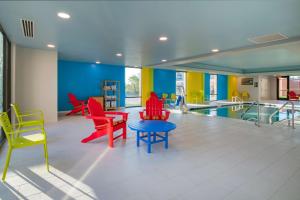 een woonkamer met kleurrijke stoelen en een zwembad bij Home2 Suites by Hilton Omaha I-80 at 72nd Street, NE in Omaha