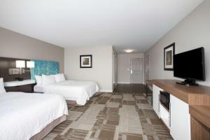 a hotel room with two beds and a flat screen tv at Hampton Inn Bellevue in Bellevue