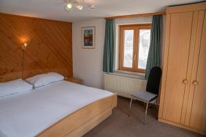 a bedroom with a bed and a chair in it at Alte Bock 2.0 in Grächen