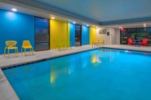 a large swimming pool with chairs and a table at Tru By Hilton Omaha I 80 At 72Nd Street, Ne in Omaha