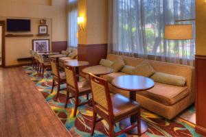 - une salle d'attente avec des tables, un canapé et des chaises dans l'établissement Hampton Inn & Suites Ontario, à Ontario