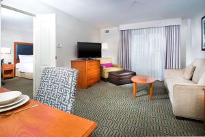 a living room with a couch and a television in a hotel room at Homewood Suites by Hilton Ontario Rancho Cucamonga in Rancho Cucamonga