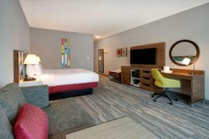 a hotel room with a bed and a desk and a television at Hampton Inn & Suites By Hilton Rancho Cucamonga in Rancho Cucamonga