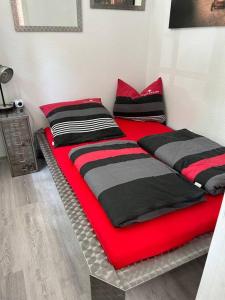 2 Betten in einem Zimmer mit rot und schwarz in der Unterkunft Ruhige Wohnung im Fabrikstil in Chemnitz in Chemnitz