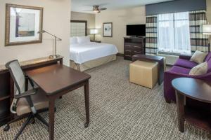 a hotel room with a bed and a desk at Homewood Suites by Hilton Munster in Munster
