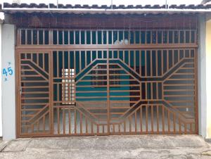 a metal gate with a door with at Cantinho mãe e filhos in Aparecida