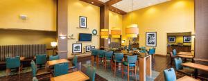 een eetkamer met tafels en blauwe stoelen bij Hampton Inn & Suites Chesapeake-Square Mall in Chesapeake