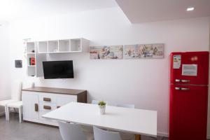 een keuken met een witte tafel en een rode koelkast bij Casa Mirea di Teti con piscina a Macari in Macari