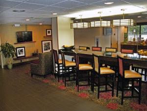 un bar con sillas y una mesa en un restaurante en Hampton Inn Norfolk/Chesapeake - Greenbrier Area en Chesapeake