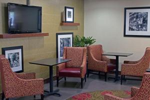 a waiting room with tables and chairs and a flat screen tv at Hampton Inn Norfolk/Chesapeake - Greenbrier Area in Chesapeake