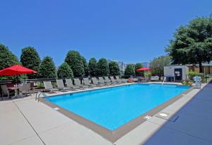 a swimming pool with chairs and umbrellas at a hotel at Hampton Inn Norfolk/Chesapeake - Greenbrier Area in Chesapeake