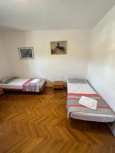 Habitación con 2 camas y suelo de madera. en Hostel on the road trip, en Materija