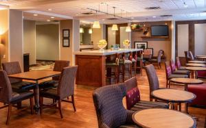 a restaurant with tables and chairs and a bar at Hampton Inn Gloucester in Gloucester