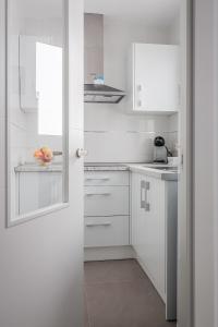 a white kitchen with white cabinets and a window at Algaba Severo Ochoa 1 in La Algaba