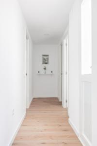 an empty hallway with white walls and wood floors at Algaba Severo Ochoa 1 in La Algaba