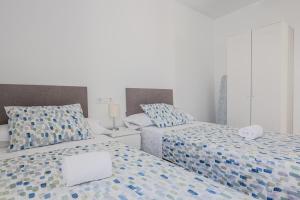 a bedroom with two beds with blue and white at Algaba Severo Ochoa 1 in La Algaba