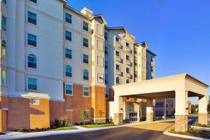 an apartment building with a parking garage in front of it at Homewood Suites by Hilton Virginia Beach in Virginia Beach