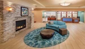 a living room with a blue couch and a fireplace at Homewood Suites by Hilton Virginia Beach in Virginia Beach