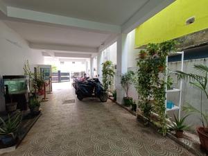 uma moto estacionada numa sala com plantas em Hotel BlueSky Ramapuram em Chennai