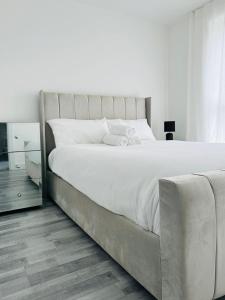 1 dormitorio con 1 cama blanca grande con marco de plata en Stylish new built double bed, en Mánchester